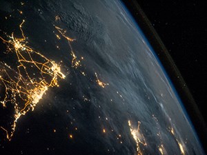 Earth seen from space at night with lights over a continent.