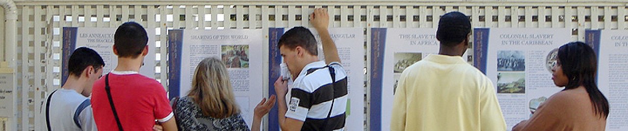 Six people standing in front of the Shackles of Memory exhibit, reading the panels, at Timucuan Ecological and Historic Preserve