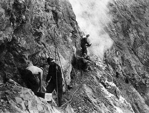 Civilian Conservation Corps enrollees construct a portion of the River Trail along a ledge around 1935.
