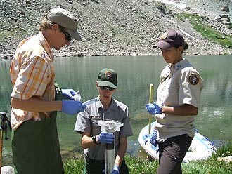 Interns collect samples along a lake's edge at Rocky Mountain National Park