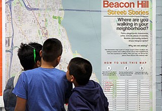 Students gather around a map of their neighborhood, Beacon Hill.