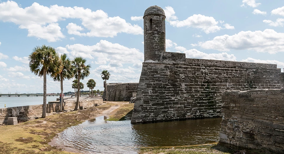 Damage caused by Hurricane Irma at Castillo de San Marcos National Monument. masonry fort wall with flood waters and palm trees
