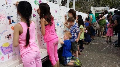 lt= Children draw on the Friendship Mural during the Cherry Blossom Festival.