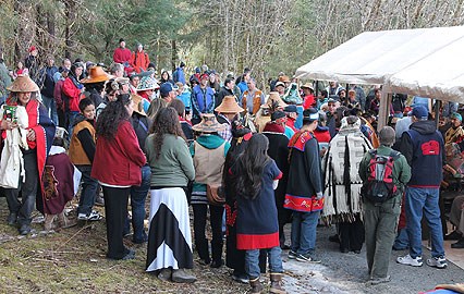 A large group gathers around to witness the  groundbreaking of the Huna Tlingit Tribal House.