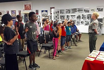 A ranger is swearing in Jr. Rangers in a classroom setting