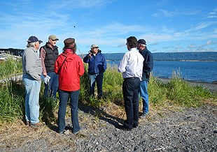 Community members discuss the trail project on the banks of Kachemak Bay.