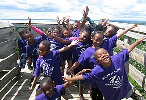 A group of grade school students participate in Ice Age Trail Alliance program activities on a boardwalk trail.