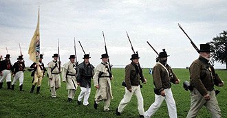 lt= Volunteers in period clothing reenact the War of 1812.