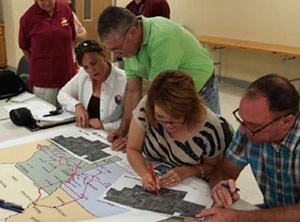 lt= Community members work on maping out features along a future hiking and biking trail.