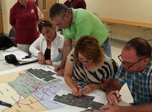 Community members work on maping out features along a future hiking and biking trail.