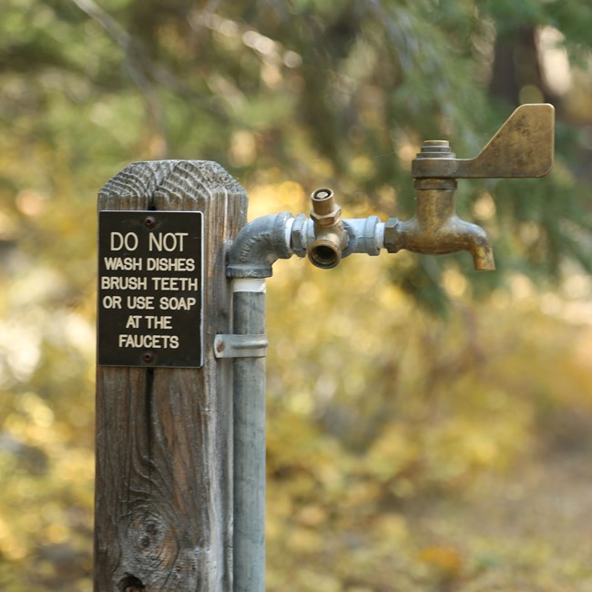 Close up of a spigot saying: Do not was dishes, brush teeth, or use soap at the faucets