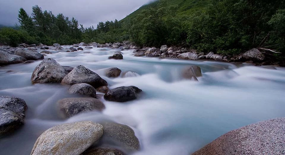 Little Sustina Flowing water moving over large tumbled boulders in the riverbed.