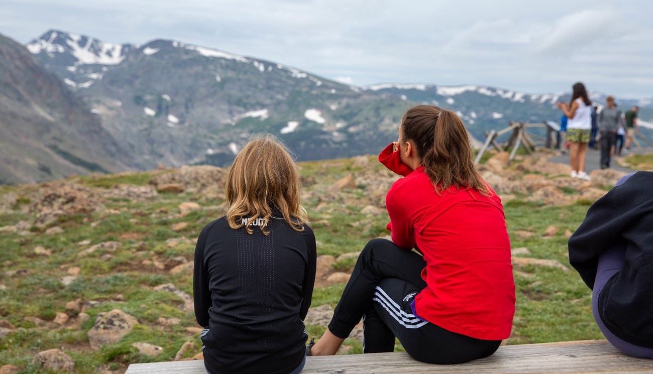 Two visitors take in the view from a bench