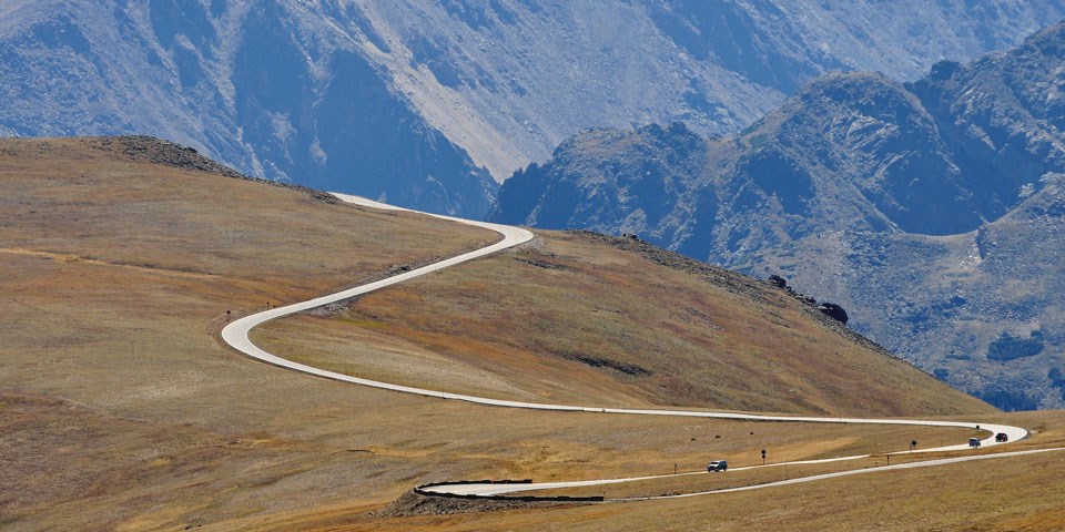 Cars drive Trail Ridge Road, which takes visitors across Rocky's alpine tundra at elevations of over 12,000 feet.