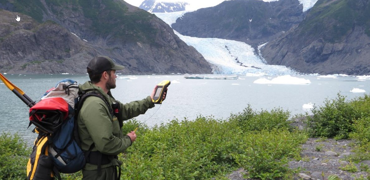 A park staffer collecting GPS coordinates near an Alaska glacier