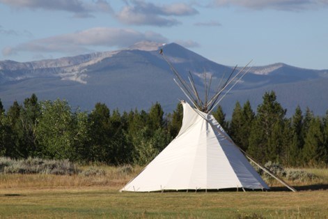 A tipi on a sunny day with the mountains in the background. A tipi on a sunny day with the mountains in the background.