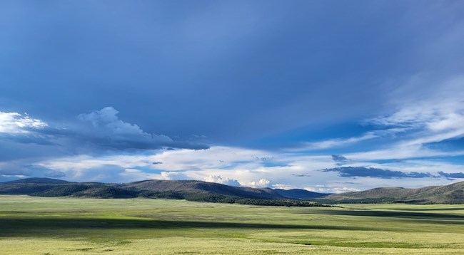 View across a green landscape with mountains in the background