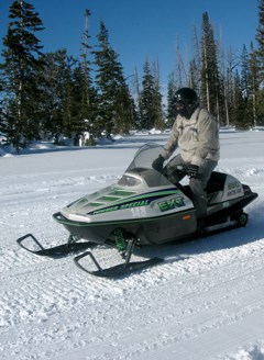 Person on a snowmobile in a winter landscape