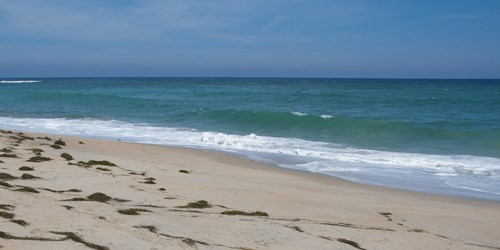 Ocean waves washing up on a sandy beach.