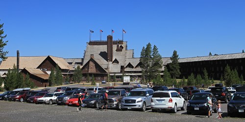 Cars in a parking lot in front of a large lodge building