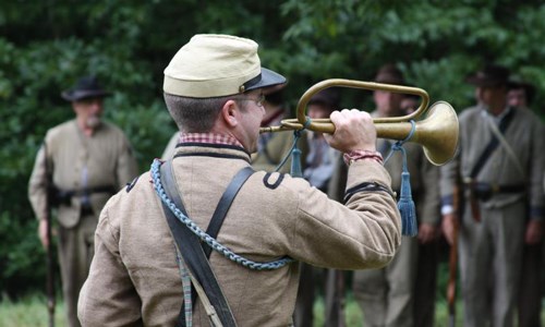 Man in military uniform playing a bugle