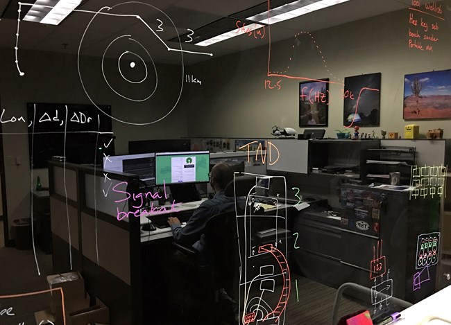Damon Joyce's reflection is visible on the tech lab black board, where ideas develop and evolve.