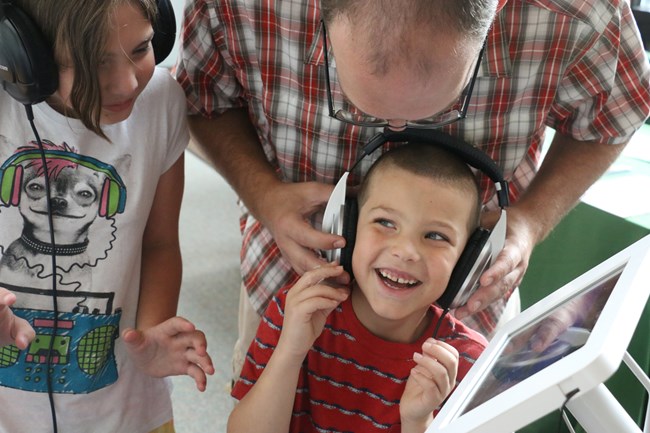 A young boy enjoys a listening activity. A young boy enjoys a listening activity.
