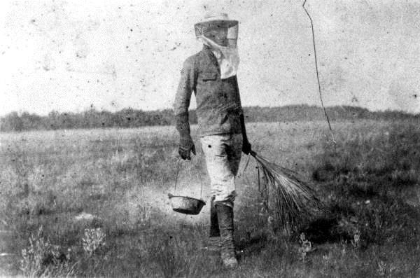 A man in Cape Sable carrying a smudge pot and a palmetto leaf