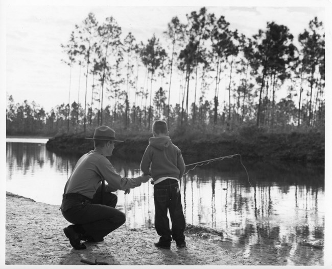 Williams_Fishing_EVER17459 A park ranger helping a young boy cast a fishing rod