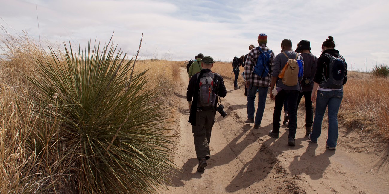 Youth Hikers in Badlands A group of youth walk on a dirt hill