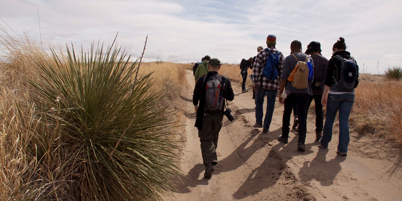 A group of youth walk on a dirt hill