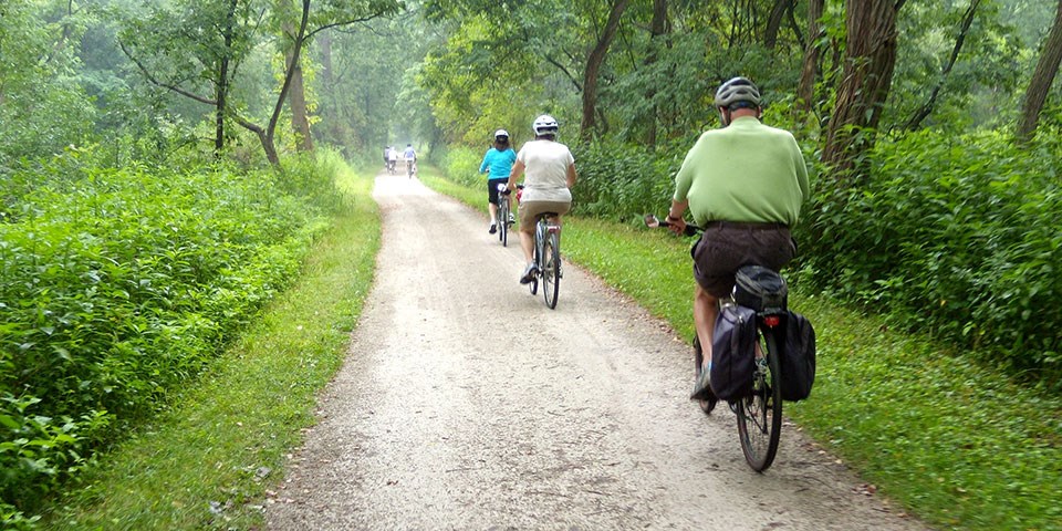 People on bikes ride on a dirt path