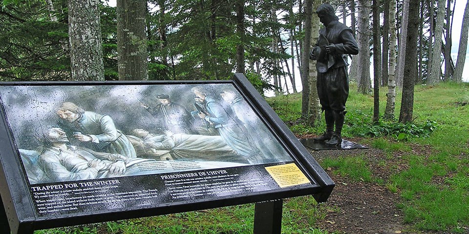 Saint Croix wayside sign in front of a statue