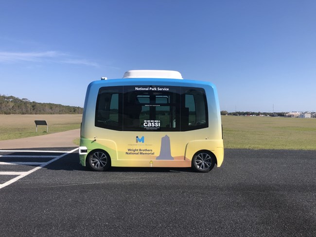 Wright Brothers National Memorial shuttle demonstration vehicle driving a park road