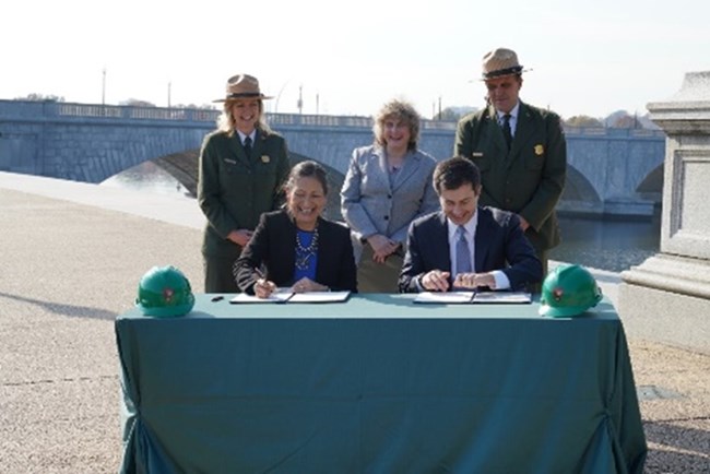 Secretary Deb Haaland and Secretary Pete Buttigieg signing an MOU