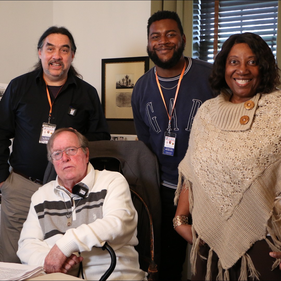 Four people posing in a room representing the Network to Freedom and Samuel Proctor Oral History Program - an older white man seated, a white man standing, and an African American man and woman standing alongside.
