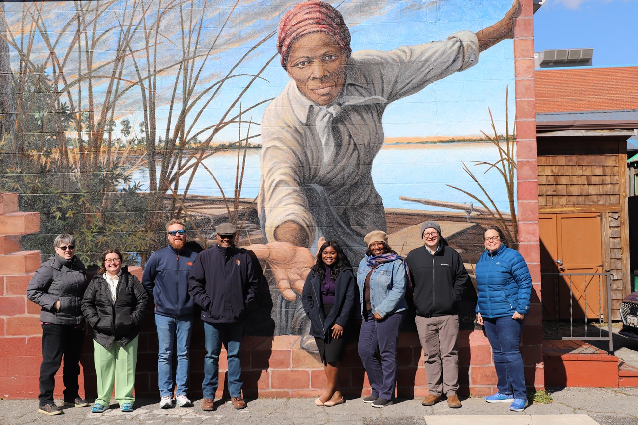 Group standing in front of Harriet Tubman mural
