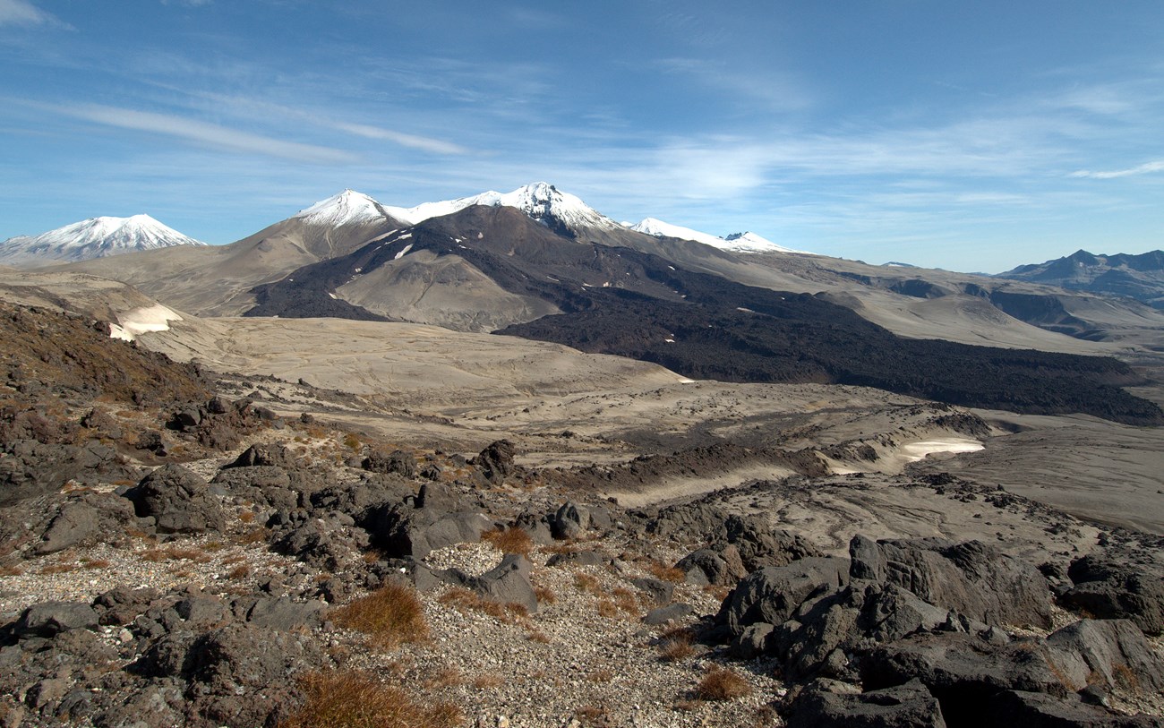 photo of a mountainous landscape with dark lava flows on the slopes