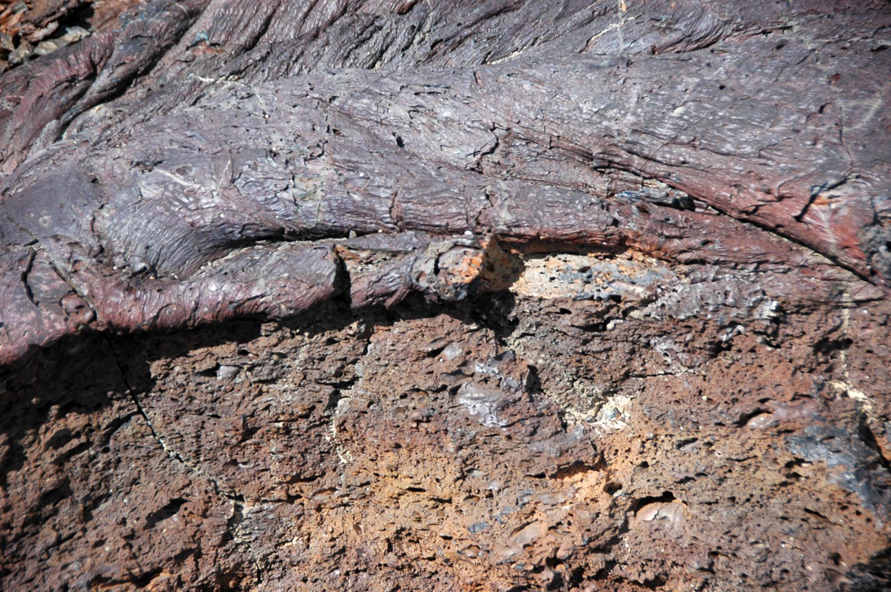Photo of a contact between ropy and blocky lava rocks.