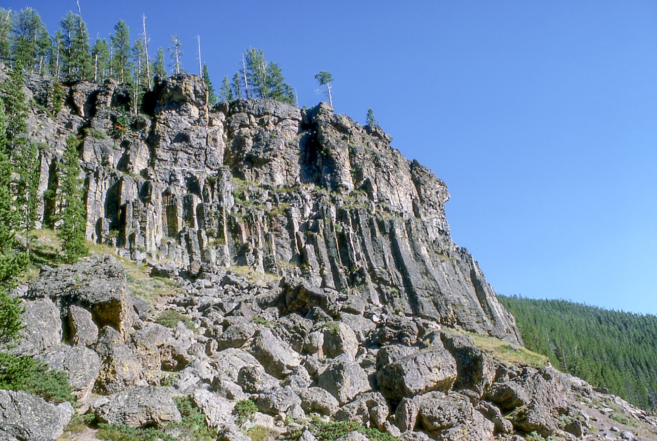 photo of a steep rocky cliff with columnar jointing