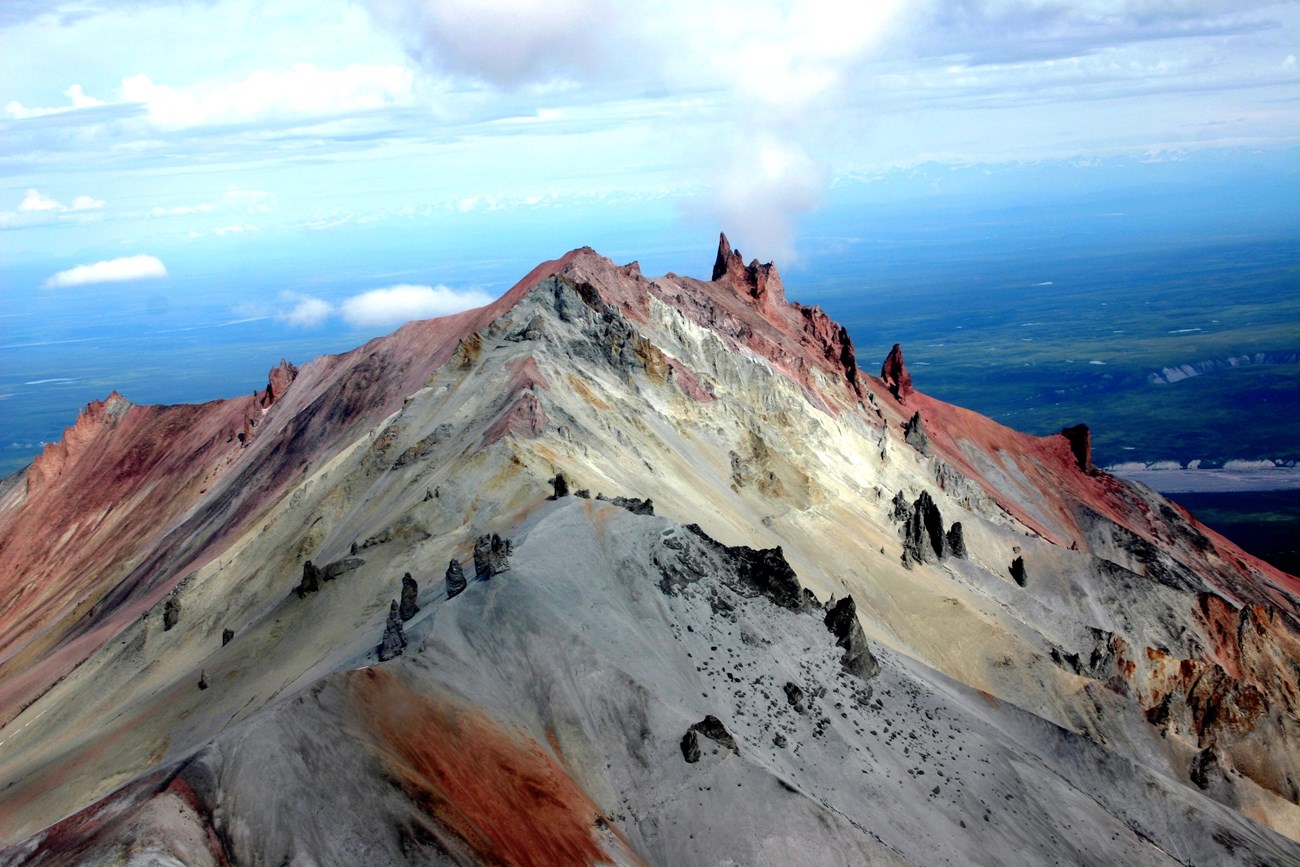 photo of a volcanic mountain peak with colorful rock outcrops
