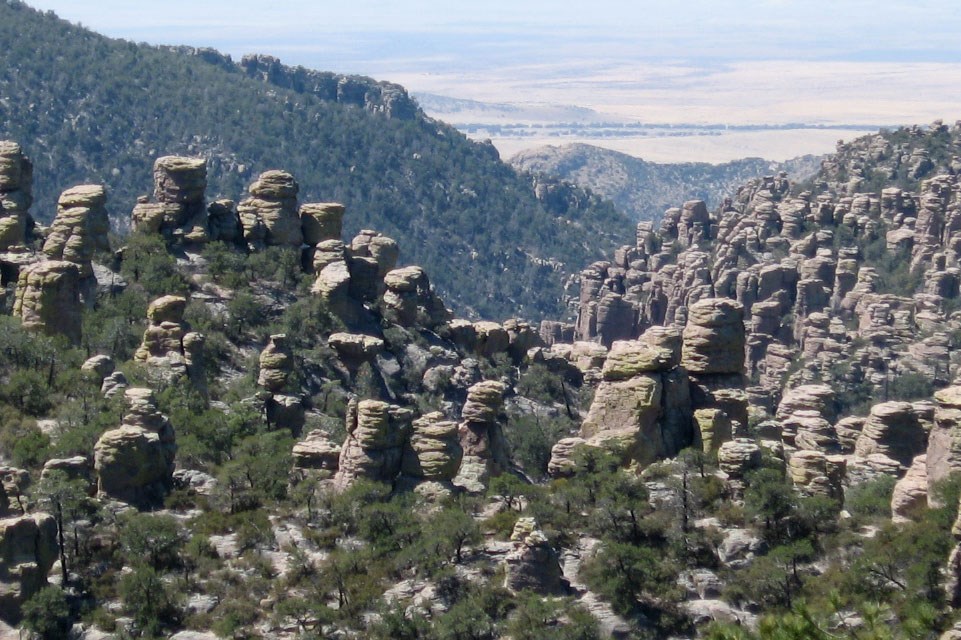 photo of a mountain side valley with rocks spires