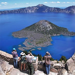 photo of people looking at crater lake and wizard island
