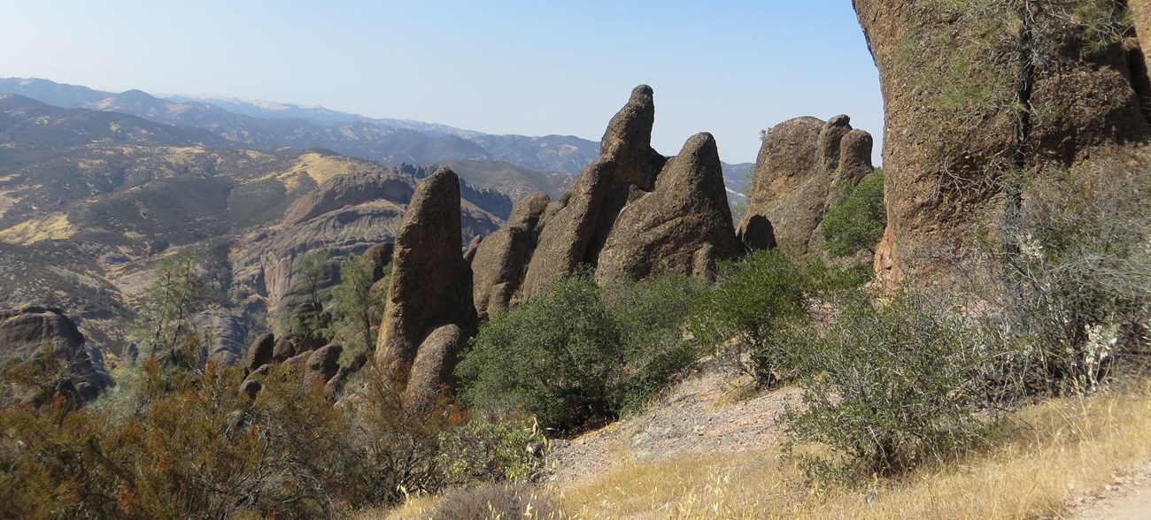 photo of rock spires in the foreground and mountainous region in the distance