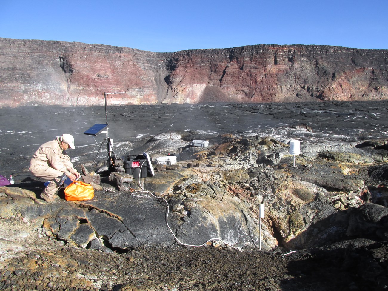 Photo of a person in the field investigating a volcanic crater.