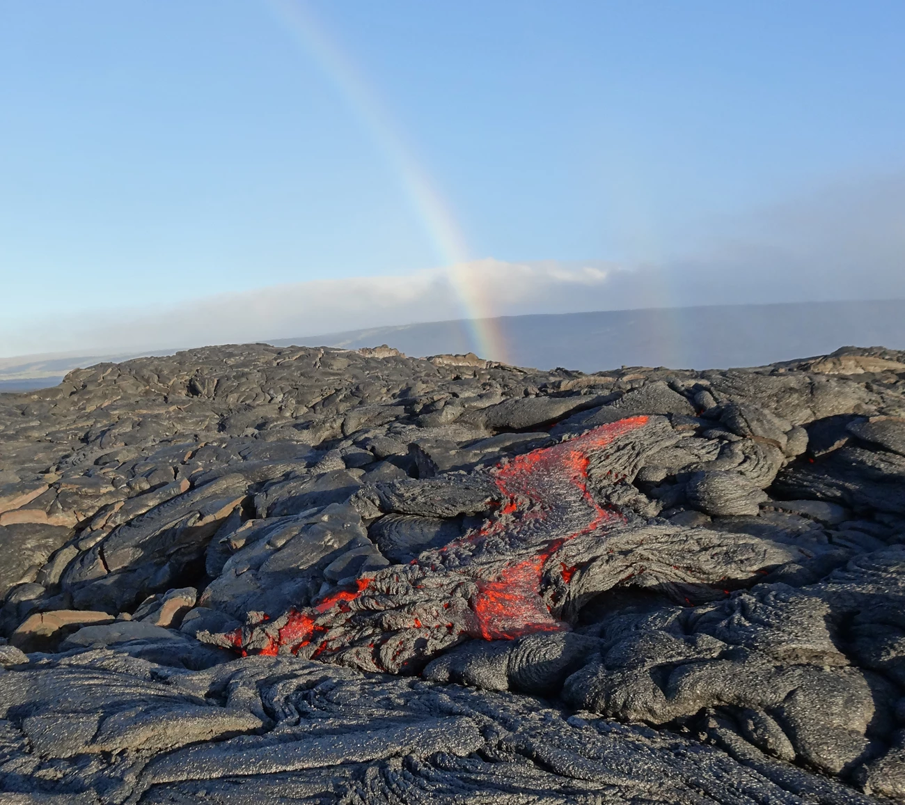 vhp_img4470 photo of a lava flow with molten rock and a rainbow