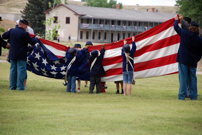 Volunteers work together to raise an American flag