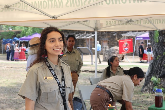 A photo of Victoria, Community Volunteer Ambassador from San Antonio Missions National Historical Park smiling while facing away from the camera.