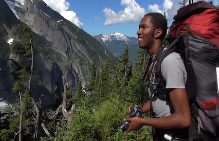 Hiker enjoys the wilderness views and prepares to take a photograph.