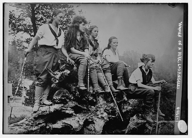 A group of young women carrying walking sticks, seated on ground. Library of Congress. https://www.loc.gov/item/2014706201/